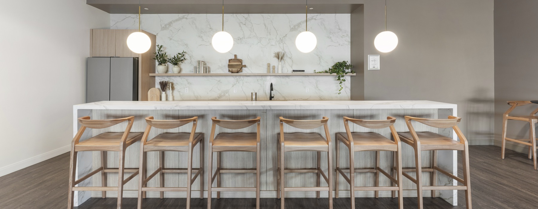 Modern resident lounge and catering kitchen at 75 Tresser in Stamford, CT, featuring a marble island and bar seating.
