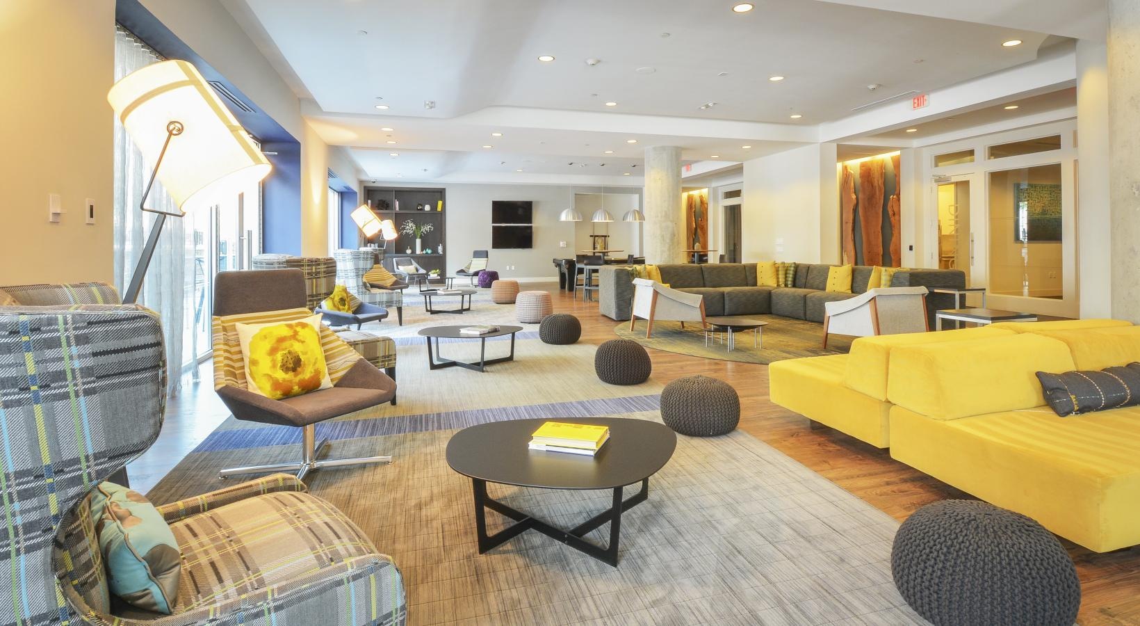 A perfect fit for the whole family Resident lounge featuring wood grain flooring and couches at our apartments for rent in Stamford, CT.