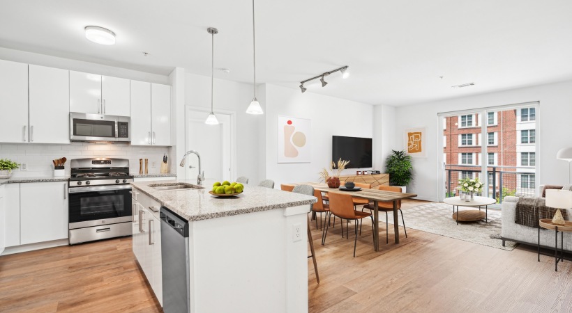 Wide open living areas perfect for entertaining	 View of kitchen island, white cabinetry, and peek of living room and seperate dining area.
