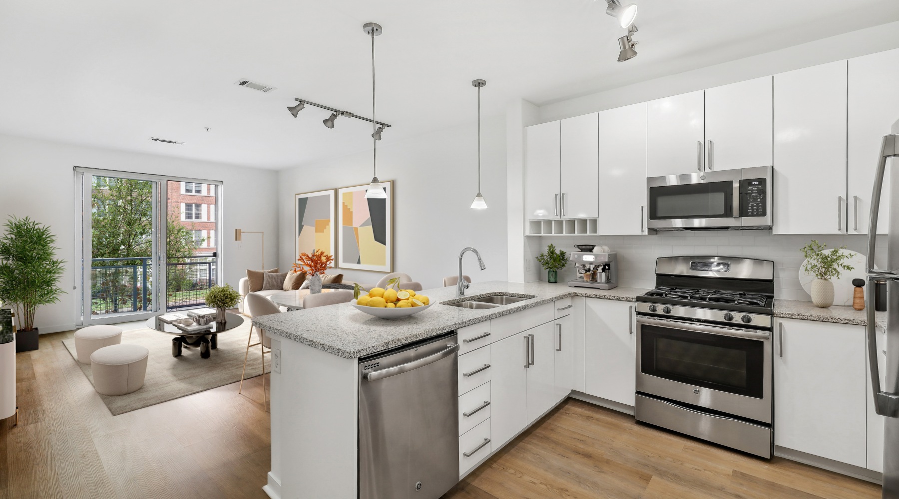Modern apartment kitchen at 75 Tresser in Stamford, CT, featuring white cabinets, stainless steel appliances, and tile backsplash.