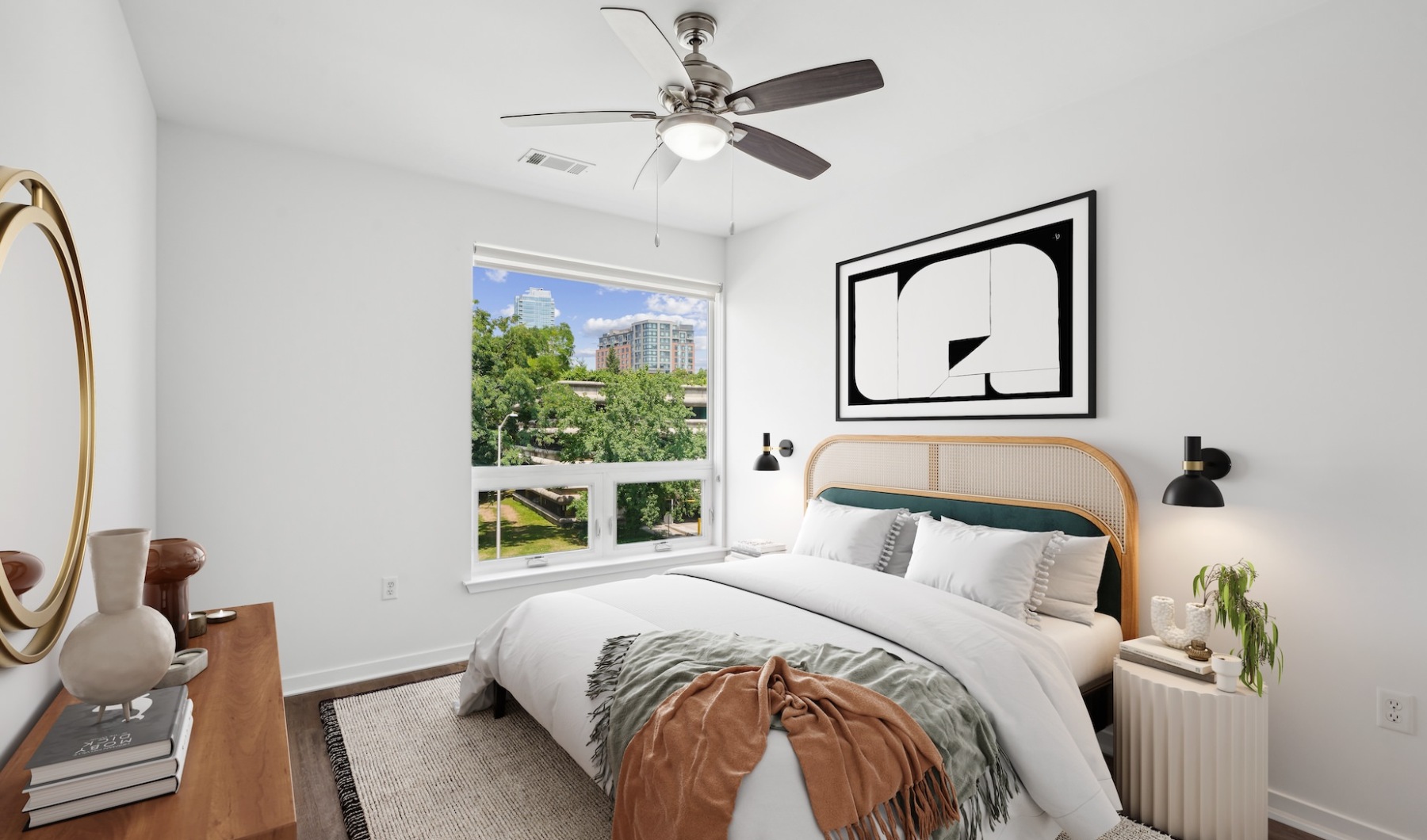 Sunlit bedrooms Bedroom at an apartment for rent in Stamford, CT, with a bed, side tables, dresser, a window, and a fan.