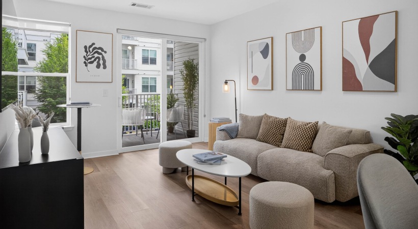 Relax and unwind in well-lit living areas Model living room featuring wood grain floor paneling and a dining room table at our apartments for rent in Stamford, CT.