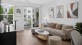 Model living room featuring wood grain floor paneling and a dining room table at our apartments for rent in Stamford, CT.