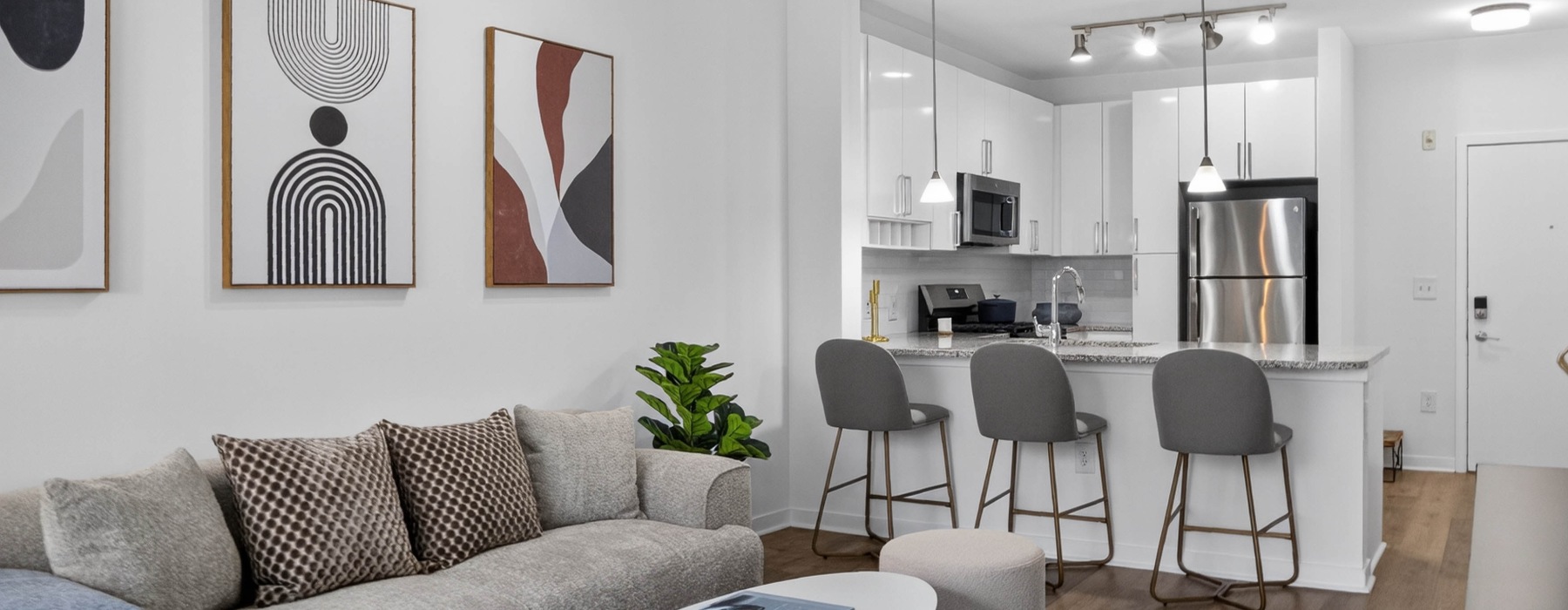 Kitchen with white cabinetry, stainless steel appliances and a kitchen island  with barstool seating