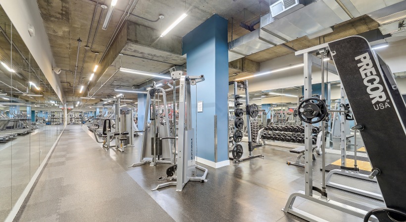 Fitness center with cardio and weight training equipment and a wall of mirrors