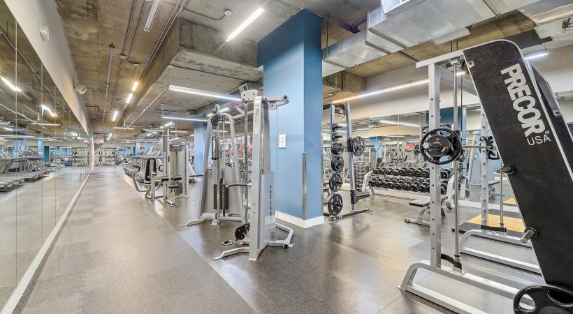 Fitness center with cardio and weight training equipment and a wall of mirrors